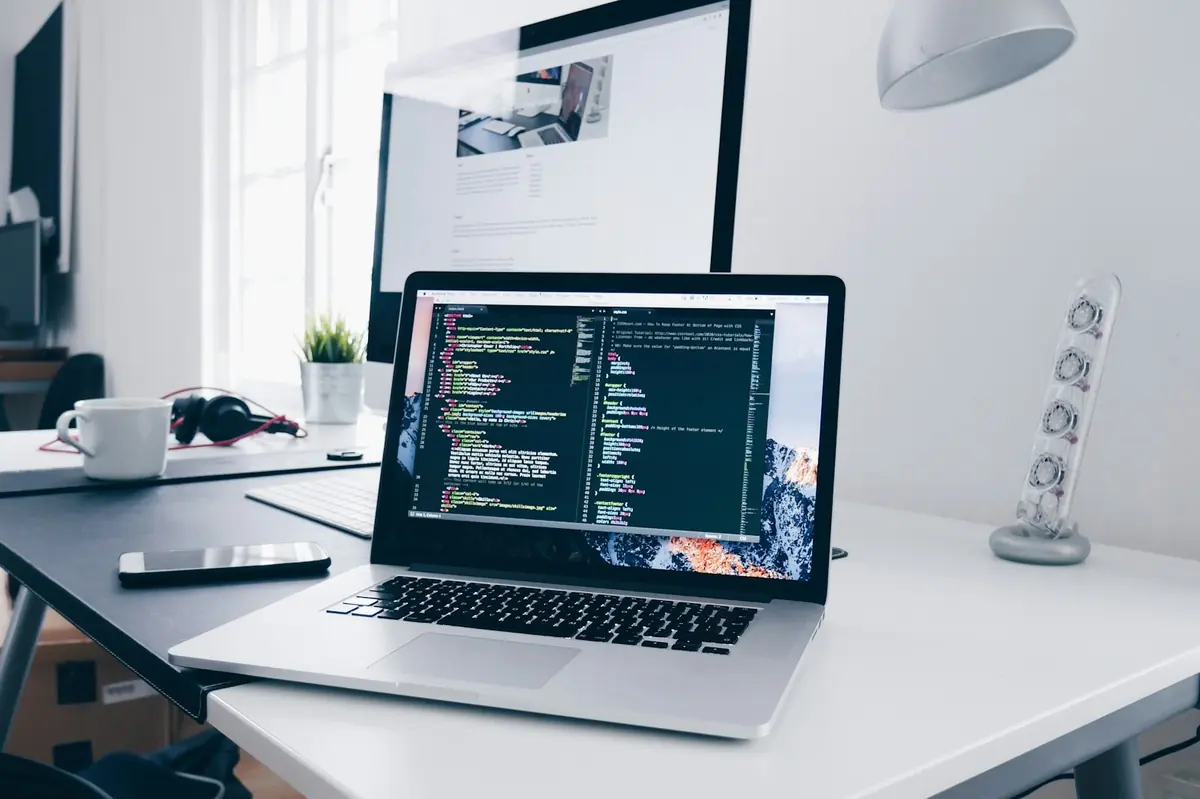 Portátil con código en pantalla sobre un escritorio de trabajo luminoso